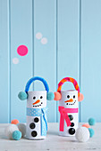 Whimsical snowman decorations made from toilet roll cores, pipe cleaners and pompoms