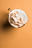 A glass of coffee with whipped cream and cinnamon