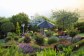 Hanggarten mit Pavillon und Beet mit Rosenstämmchen, eingefasst mit Buchshecke