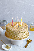 Honey cake with burning candles for birthday