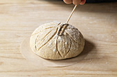 Preparing country bread: cut a pattern into dough pieces