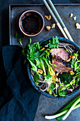 Asian noodle soup with grilled duck breast and pak choi