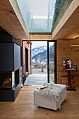 Fireplace and ottoman in front of patio doors