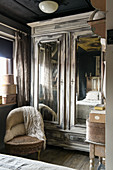 Old, shabby-chic wardrobe and vintage-style accessories in bedroom