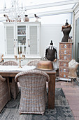 Wicker chairs around dining table in shabby-chic conservatory