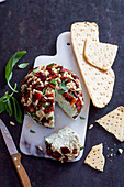 Cheese ball with dried tomatoes, pine nuts and pesto