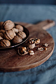 Walnuts in the shells and opened on a wooden board