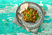 Veganes Currygericht mit Berglinsen, Zucchini, Zuckerschoten und Spinat