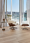 Eames Lounge Chair next to glass wall with panoramic view in living room