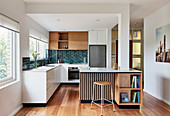 Open-plan kitchen with different fronts in white and wooden finishes