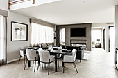 Luxuriöser offener Wohnraum in Grautönen mit gedecktem Tisch