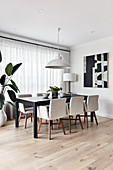 Upholstered chairs around black table in elegant dining room