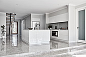 Steps leading up to white, modern, minimalist, open-plan kitchen