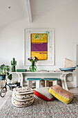 Framed art above console table with floor cushions