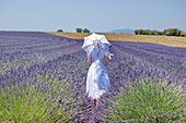 Woman holding parasol in field of lavender