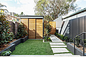 Small modern garden with screen fence and garden wall