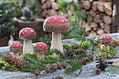 Forest look with toadstools made of wood, fir branches, and pinecones