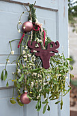 Mistletoe with Christmas tree ornaments, fir branch, and deer silhouette as a door decoration