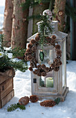 Lantern with wreath of larch cones, fir branch and Christmas tree decorations