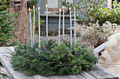 Advent wreath made of fir branches and sloe with berries, silver candles