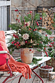 Weihnachtsstrauß aus Zweigen von Nordmanntanne, Kiefer, und Zierapfel, mit Strohsternen geschmückt