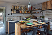 Rustic kitchen with wooden island counter and metal bar stools