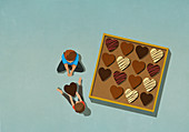 Man giving heart shape chocolate to woman