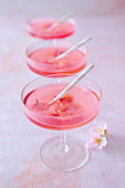 Cocktails made with pink vermouth, gin and and preserved Japanese cherry blossom