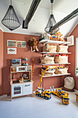 Kinderküche, Regale und Spielsachen im Kinderzimmer mit terrakottafarbener Wand