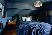 Schlafzimmer ganz in Blau mit antiker Deko und Dachschräge