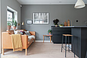 Cognac-colored sofa in a modern kitchen in grey