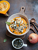 Pumpkin smoothie bowl with apple, coconut chips and ginger