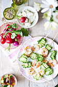 Cold cucumber-shrimp skewers, served with radishes and a dip
