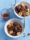 Schoko-Pancakes ohne Mehl und Zucker serviert mit Bananenscheiben und Nüssen