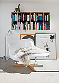 Classic chair, modern art, and bookshelf in the room