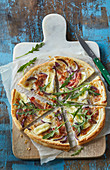 Puff pastry pizza with cheese and striped bacon