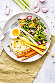 Pea shoot salad with vegetable, boiled egg and hummus