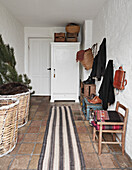 White painted entry way with runner rug on the terracotta tiled floor