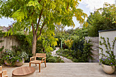 Terrasse mit Stuhl, Blick in den Garten mit Kiesweg