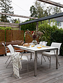 Dining table and chairs below pergola
