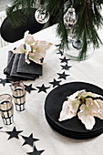 Table set in black and white and decorated with flowers for Christmas meal