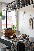 Mushrooms, potatoes, cookbook and wooden box on kitchen island with rack