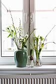 Vases of white spring flowers: tulip, anemone, willow catkins, waxflower, hyacinths, star-of-Bethlehem and cherry branch