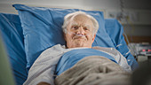 Elderly man resting in hospital bed