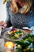 Frau isst festlichen Hummersalat mit Kartoffeln, Bohnen und Radicchio