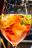Campari cocktail with ice and fresh mint (close-up)