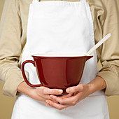 Woman holding a mixing jug and wooden spoon