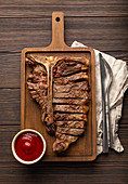 In Scheiben geschnittenes Medium Rare T-Bone-Steak mit Ketchup