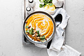 Creamy carrot curry soup topped with cashews, coconut cream and cilantro