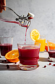 Pomegranate juice being poured into orange juice